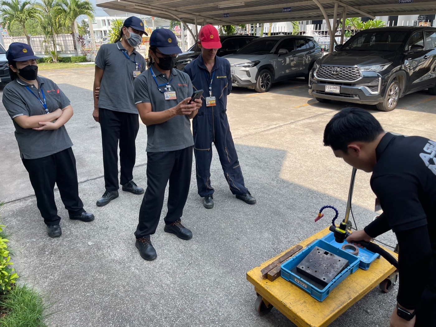 Customers watching a handheld laser cleaning unit demonstration outside the showroom